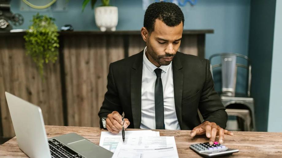 A company director working through figures with a calculator
